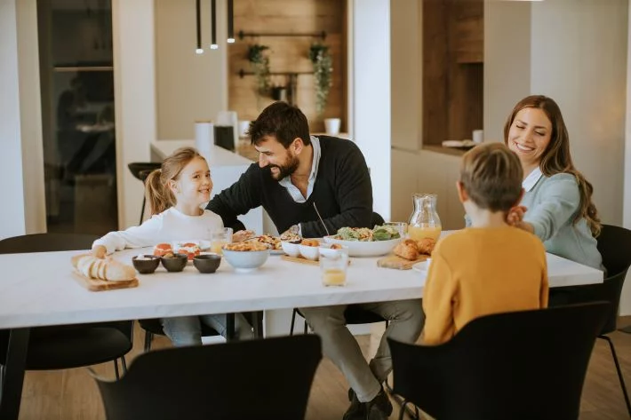 A family enjoys lunch together at the dining table at home.
