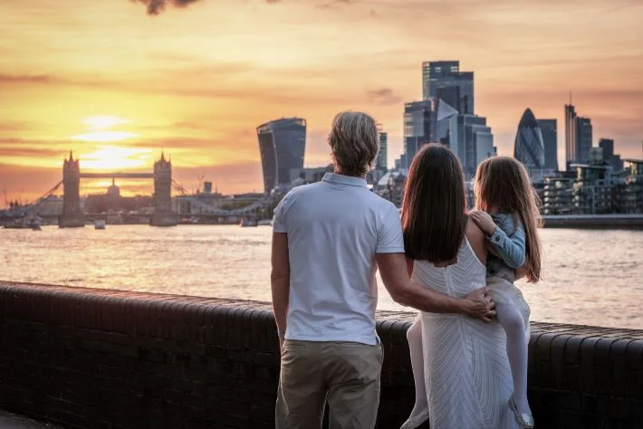 A family looks at the skyline of London, England, during a beautiful sunset.