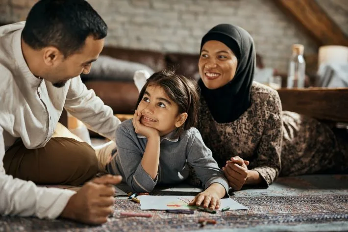 Muslim mother, father and daughter spending time together at home