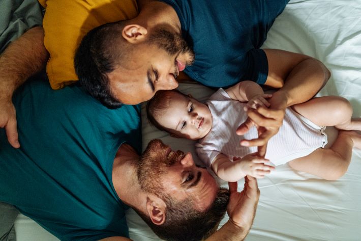 Gay couple enjoying parenthood with their baby girl.