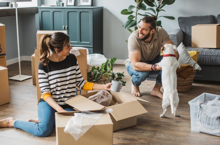 A happy, unmarried couple unpacking boxes in their new home. New laws for cohabiting couples