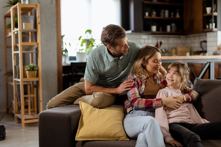 Happy family relaxing on sofa together.